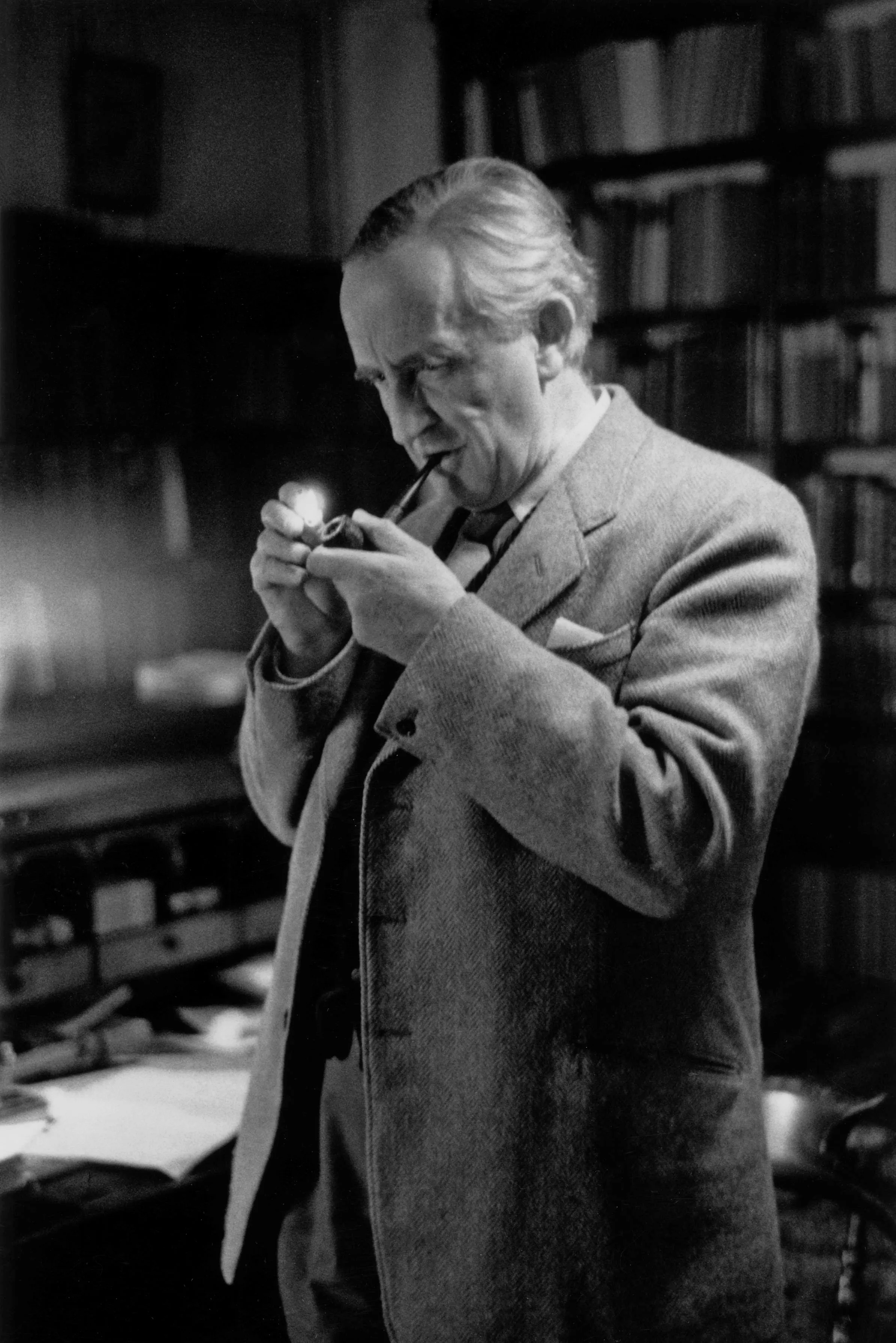 Photo : John Ronald Reuel Tolkien allumant sa pipe, dans son bureau au 20 Northmoor Road à Oxford, année 1955.