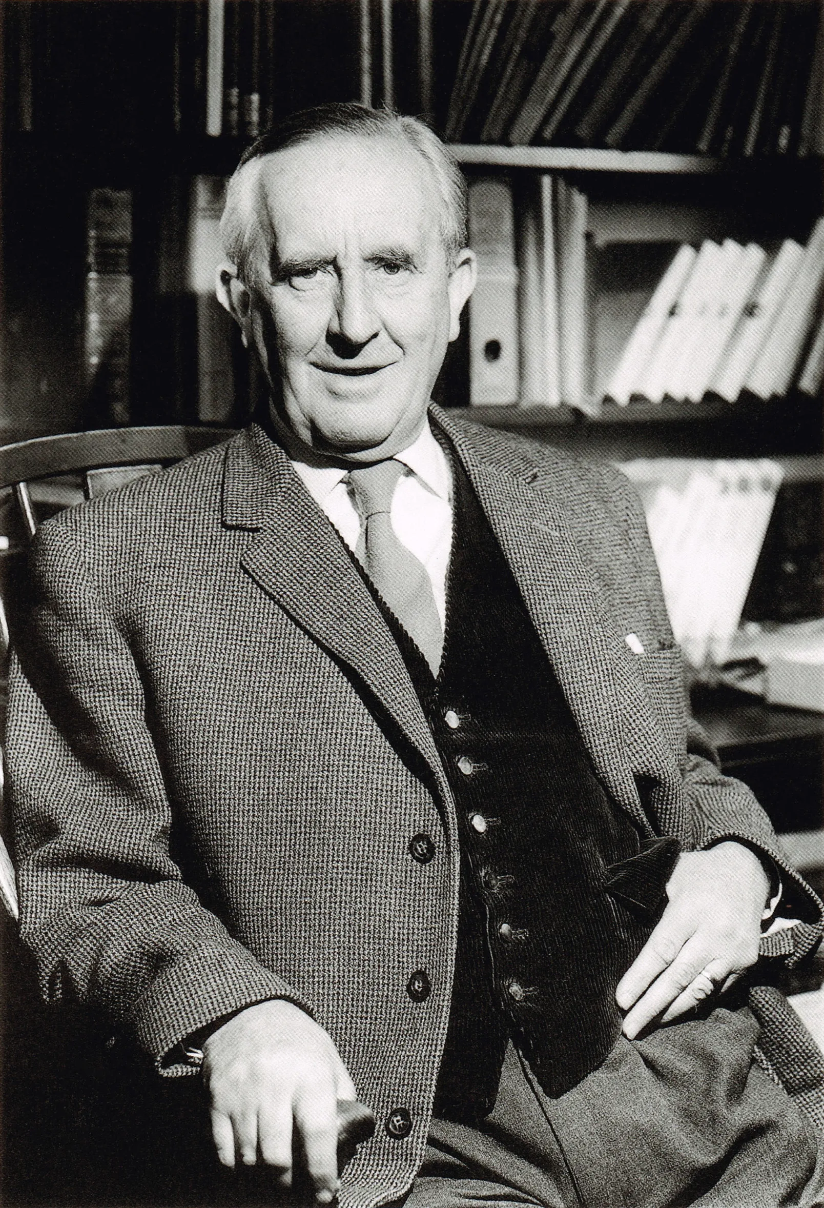 Photo : John Ronald Reuel Tolkien, posant près de sa bibliothèque, au 76 Sandfield Road à Oxford, année 1961.