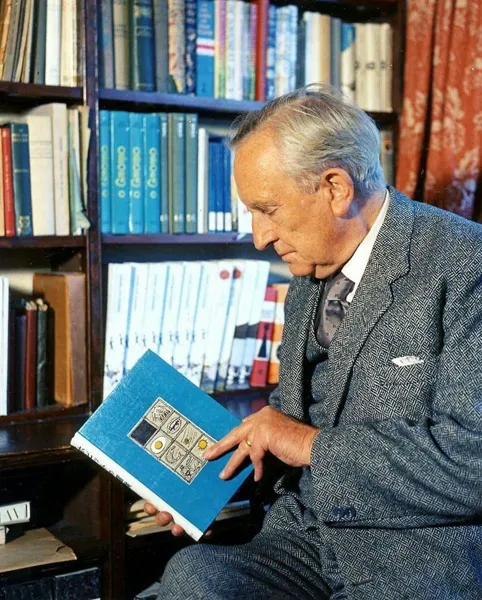 Photo : John Ronald Reuel Tolkien, feuilletant un livre de sa bibliothèque, au 76 Sandfield Road à Oxford, année 1961.